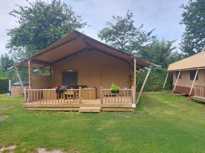 Glampingtent Sunshine en Molengroet, Países Bajos, con terraza de madera y césped al frente.