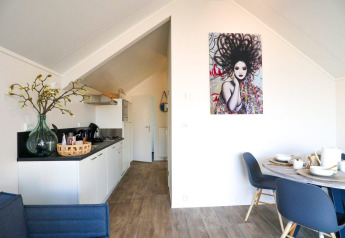 Interni moderni della lodge Beach House a Bad Hulckesteijn, Paesi Bassi, con cucina e zona pranzo.