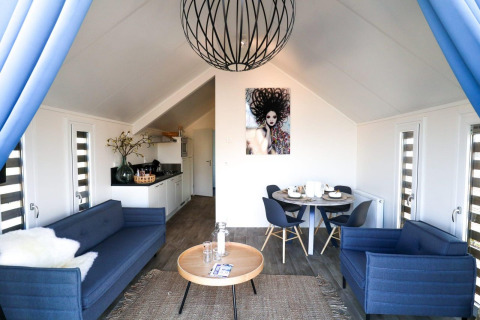 Modernes Wohnzimmer im Beach House bei Bad Hulckesteijn, Niederlande, mit blauen Sofas und Kunst.