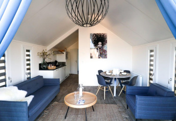 Modernes Wohnzimmer im Beach House bei Bad Hulckesteijn, Niederlande, mit blauen Sofas und Kunst.