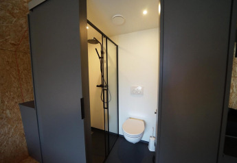 Moderne badeværelse på Solo Retreat ved Bad Hulckesteijn i Holland med bruser og væghængt toilet.