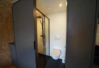 Bagno moderno al Solo Retreat di Bad Hulckesteijn, Paesi Bassi, con doccia e wc sospeso a muro.