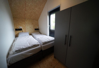 Kamer in Solo Retreat in Bad Hulckesteijn, Nederland, met twee eenpersoonsbedden en grote kledingkast.