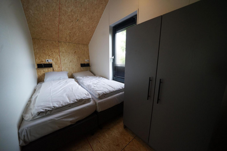 Habitación de Solo Retreat en Bad Hulckesteijn, Países Bajos, con dos camas individuales y armario grande.
