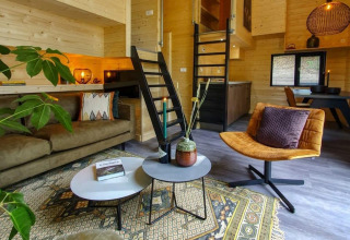 Accogliente soggiorno moderno nel Tiny House a Bad Hulckesteijn, Olanda, con interni in legno e soppalco.