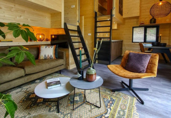 Accogliente soggiorno moderno nel Tiny House a Bad Hulckesteijn, Olanda, con interni in legno e soppalco.