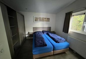 Dormitorio en L-Pavilion, Poort van Zeeland, Países Bajos, con dos camas individuales y ropa de cama azul.