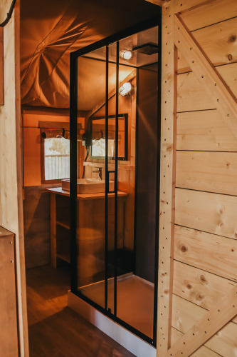 Innenaufnahme eines Safari-Zeltes mit eigenem Bad und Dusche auf dem Campingplatz Luna del Monte.