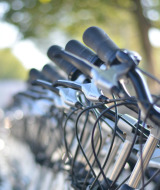 Row of bicycle handlebars and brake levers at a holiday park offering glamping accommodations outdoors.