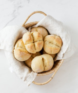 Una cesta de panecillos recién horneados sobre un paño blanco, lista para servir en el desayuno o brunch.