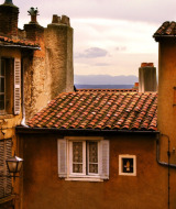 Vista de casas antiguas con tejados de teja y chimeneas en Royat, Auvergne-Rhône-Alpes, Francia, al atardecer.