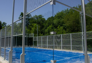 Outdoor padel court with a bright blue surface at Camping Etxarri holiday park in Navarra, Spain.