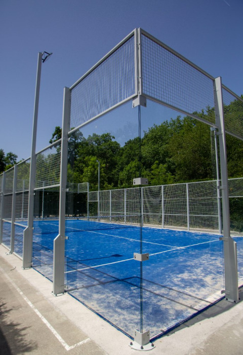 Udendørs padelbane med blå belægning ved Camping Etxarri feriepark i Navarra, Spanien, omgivet af skov.