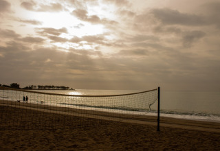 Strand mit Volleyballnetz bei Sonnenuntergang im TAIGA Almeria Playa, einem Ferienpark in Andalusien, Spanien.