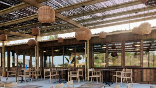 Terraza exterior en el parque vacacional TAIGA Almeria Playa en Andalucía con muebles de madera y lámparas.
