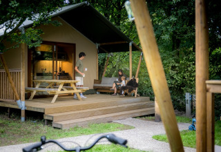 Familie genießt Zeit auf der Terrasse eines Glamping-Zeltes im Urban-Gardens Ieper, Westflandern, Belgien.