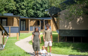 Familie går med deres barn på en sti i Urban-Gardens Ieper feriepark, Westflandern, Belgien, solskinsdag.