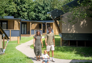 Family walks with young child on pathway at Urban-Gardens Ieper holiday park, West Flanders, Belgium.