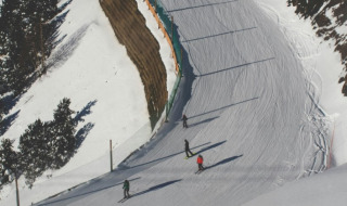 Esquiadores bajan una pista nevada cerca de Bourg Saint Maurice, Francia, rodeados de montañas y pinos.