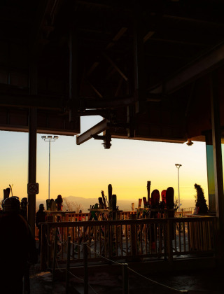 Vue sur le coucher du soleil depuis un parc de vacances glamping, avec rangement pour skis et silhouettes.