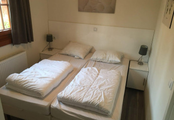 Chambre du lodge Boekhorst 4 à De Achterhoek, Pays-Bas, avec deux lits simples et décoration moderne.