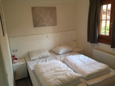 Dormitorio en Boekhorst 4 en De Achterhoek, Países Bajos, con dos camas individuales y ventana con cortinas.
