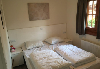 Chambre à Boekhorst 4 à De Achterhoek, Pays-Bas, avec deux lits simples et une fenêtre avec rideaux.