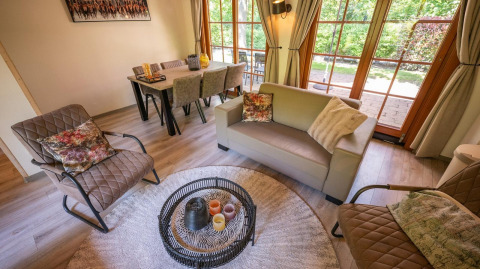 Salon confortable au Boekhorst 6, De Achterhoek, Pays-Bas, avec des meubles modernes et de grandes fenêtres donnant sur le jardin.