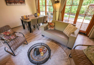 Salon confortable au Boekhorst 6, De Achterhoek, Pays-Bas, avec des meubles modernes et de grandes fenêtres donnant sur le jardin.