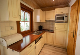 Acogedora cocina en la cabaña Boekhorst 6 de De Achterhoek, Países Bajos, con madera y electrodomésticos modernos.