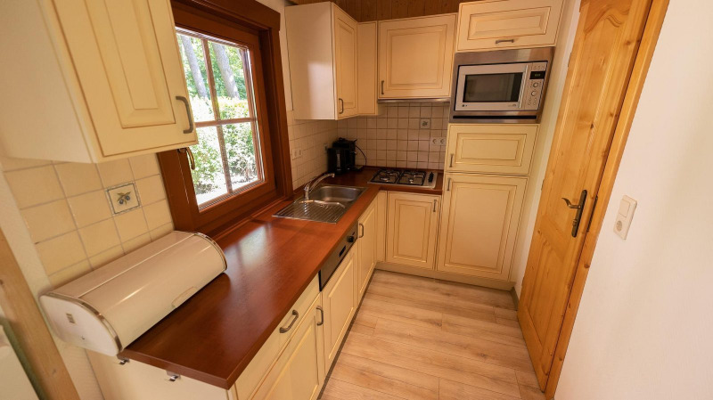 Cocina compacta en la cabaña Boekhorst 6 en De Achterhoek, Países Bajos, con muebles de madera claros.