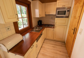 Gezellige keuken in lodge Boekhorst 6 bij De Achterhoek in Nederland met houten werkblad en lichte kasten.