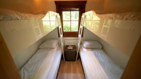 Cuatro camas individuales en literas en una habitación acogedora con ventana de madera en Boekhorst 6, De Achterhoek.