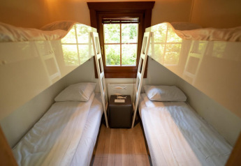 Vier eenpersoonsbedden als stapelbedden in een gezellige kamer met houten raam bij Boekhorst 6, De Achterhoek.