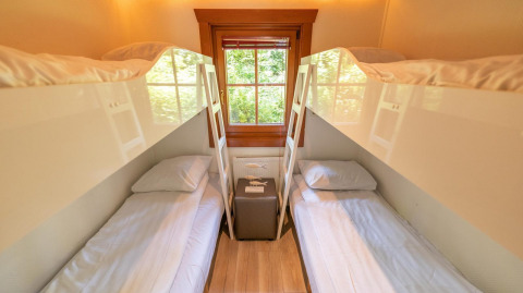 Habitación con cuatro camas y ventana, fotografiada en Boekhorst 6 en De Achterhoek, Países Bajos.