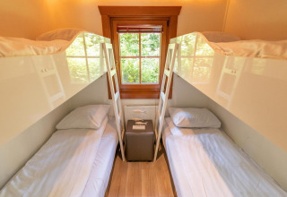 Habitación con cuatro camas y ventana, fotografiada en Boekhorst 6 en De Achterhoek, Países Bajos.