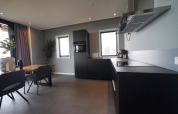 Moderne lodgekøkken med spisebord og sorte skabe i Mode 6, De Achterhoek, Holland.