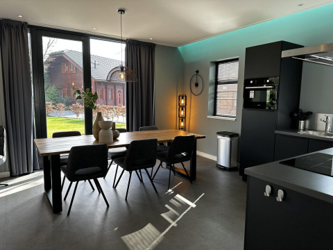 Moderne eetruimte en keuken in Modus Sauna 4 lodge bij De Achterhoek, Nederland, met groot raamzicht.