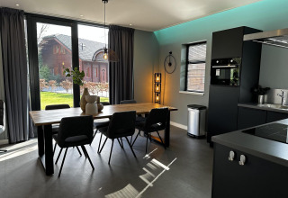 Moderne eetruimte en keuken in Modus Sauna 4 lodge bij De Achterhoek, Nederland, met groot raamzicht.