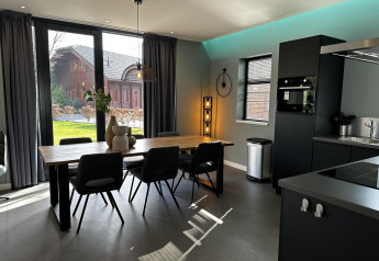 Moderne eetruimte en keuken in Modus Sauna 4 lodge bij De Achterhoek, Nederland, met groot raamzicht.