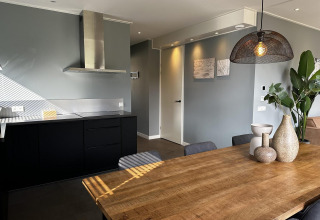 Modernes Küchen- und Esszimmer einer Lodge mit Holztisch bei Modus Sauna 4, De Achterhoek, Niederlande.