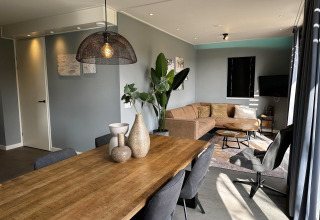 Moderne lodge woonkamer in Modus Sauna 4, De Achterhoek, Nederland, met eettafel en comfortabele bank.