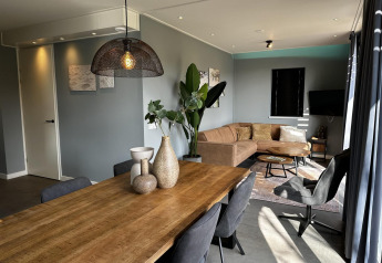 Moderne lodge woonkamer in Modus Sauna 4, De Achterhoek, Nederland, met houten tafel en gezellige zithoek.