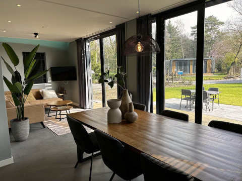 Moderne woon- en eetkamer in Modus Sauna 4 bij De Achterhoek, Nederland, met uitzicht op tuin en terras.