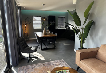 Zona de estar y comedor moderna en la cabaña Modus Sauna 4 en De Achterhoek, Países Bajos, con decoración elegante.