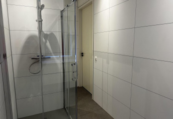Moderne douche met glazen deuren in badkamer van Modus Sauna 4, De Achterhoek, Nederland.