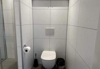 Baño moderno en Modus Sauna 4, De Achterhoek, Países Bajos, con paredes de azulejos blancos.