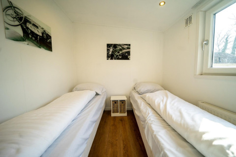Helles Zimmer im Pavilion 4 bei De Achterhoek, Niederlande, mit zwei Einzelbetten und Holzboden.