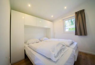 Modernes Schlafzimmer im Pavilion 4, De Achterhoek, Niederlande, mit Doppelbett und weißen Möbeln.