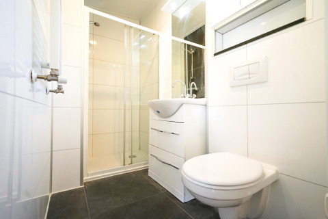 Baño moderno y compacto con ducha, inodoro y lavabo en el Pavilion 4 de De Achterhoek, Países Bajos.